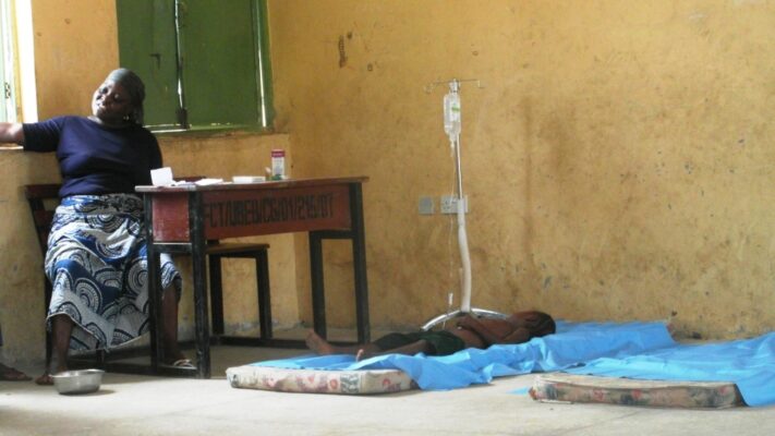 In Gaye, Abuja, a mother watches over her daughter infused for malaria in a repurposed classroom by doctors on outreach. CHIPS hope to bring free health care to communities such as Gaye.