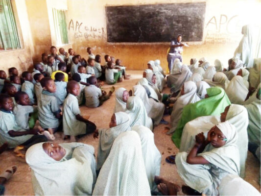 Pupils of Hammadu Primary School sitting on the floor to take lessons.