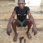 Suspected notorious armed robber, Chinedu Ani with the Beretta pistol.