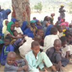 Women and children under a tree at Runde-Bin IDPs settlement