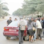 Commuters struggle to board a taxi at a bus stop in Jabi Abuja recently.