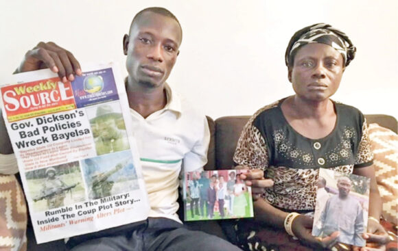 Abiri Angatimi Kenneth and Toboulayefa Jones hold photographs of their imprisoned father and husband, Jones Abiri, along with the last edition of his newspaper, published before he was imprisoned in 2016 for two years without trial. Abiri was released in August 2018, but rearrested in May 2019, charged in federal court, and released on bail in October