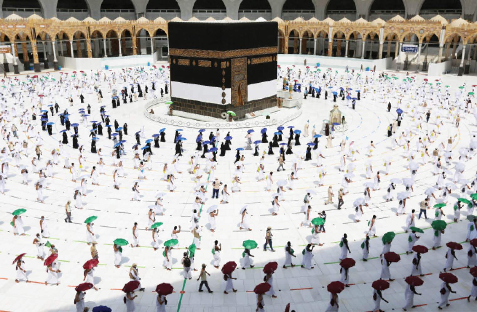 Pilgrims hold coloured umbrellas along matching coloured rings separating them as part of measures to contain the spread of coronavirus while circumambulating around the Kaaba, at the centre of the Grand Mosque in the holy city of Mecca yesterday, at the start of the annual Muslim Hajj pilgrimage. (left) Male pilgrims praying inside the Grand Mosque