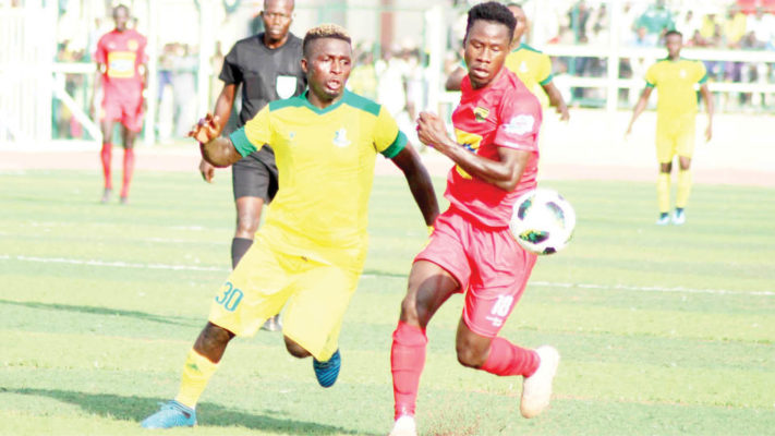 Kano Pillars player Bature Yaro battles for the ball with Fred Asiamah of Asante Kotoko in the preliminary round of this year's CAF Champions League at the Sani Abacha stadium in Kano