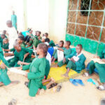 Some pupils of the school sitting outside