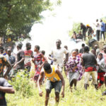 People run from tear gas shot by a police officer during the mass looting of a warehouse that has COVID-19 food palliative in Abuja yesterday. Also is a lady injured during the stampede and people carrying looted food items