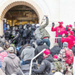 Rioters clash with police as they try to enter the Capitol building through the front doors. Rioters broke windows and breached the Capitol building in an attempt to overthrow the results of the 2020 election. Metal bars and tear gas were used Washington DC, US.