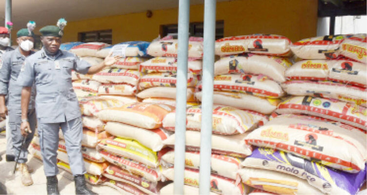 The Area Comptroller of Customs for Oyo/Osun Command, Mr Adamu Abdulkadir, showing the 3,052 bags of foreign parboiled rice seized from smugglers, at a news briefing in Ibadan yesterday.