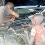 Some youths repairing a car at one of the mechanic workshop in Jalingo.