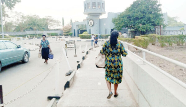 Staff and students walking in and out of University of Ibadan without mask