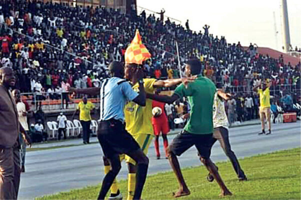 A player of Kano Pillars stopping irate fans from attacking the assistant referee who disallowed Nyima Nwagua’s goal against Akwa United
