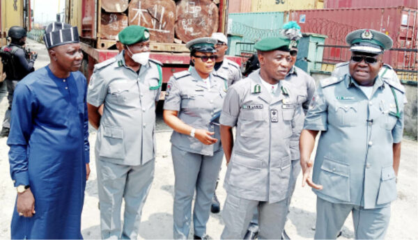 Acting Assistant Comptroller of Customs Zone ‘C, Olusemire Kayode (R) other men of the Nigeria Customs Service, Federal Operations Unit Zone ‘C during the display of Logs of unprocessed timber intercepted in Port Harcourt yesterday