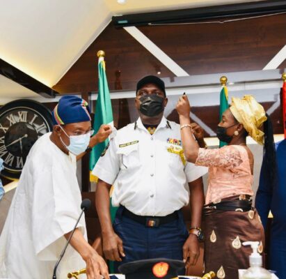 L-R. Minister of Interior Ogbeni Rauf Aregbesola decorating the newly promoted DGC and Acting CG, FFS, Samson Peremobowei Karebo, middle being assisted by his wife, Mrs Karebo, at the CDCFIB conference room in Abuja