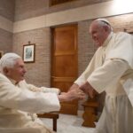 (FILES) This photo taken and handout on November 28, 2020 by The Vatican Media shows Pope Francis (R) greeting Pope Emeritus Benedict XVI following a consistory to create 13 new cardinals, on November 28, 2020 in The Vatican