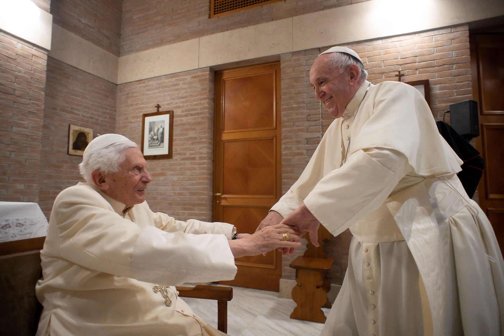 (FILES) This photo taken and handout on November 28, 2020 by The Vatican Media shows Pope Francis (R) greeting Pope Emeritus Benedict XVI following a consistory to create 13 new cardinals, on November 28, 2020 in The Vatican