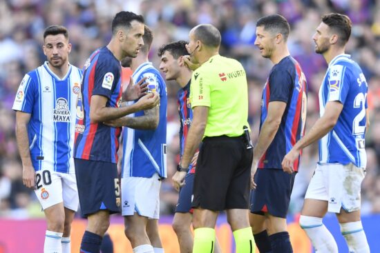 Barcelona's Spanish midfielder Sergio Busquets (2L) talks with Spanish referee Mateu Lahoz during the Spanish League football match between FC Barcelona and RCD Espanyol at the Camp Nou stadium in Barcelona on December 31, 2022. (Photo by Pau BARRENA / AFP)