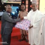 Prof. Isah Mshelgaru, Leader of a Muslim group who celebrated Christmas with Christians at EYN Church, Samaru Zaria, presenting a gift to Rev. Tijjani Chindo, during the Christmas service at Zaria on Sunday