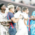FILE PHOTO: Barcelona and Real Madrid players clash during a pre-season game last year