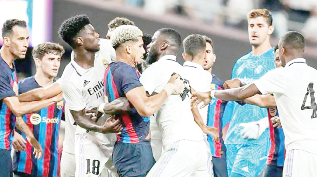 FILE PHOTO: Barcelona and Real Madrid players clash during a pre-season game last year