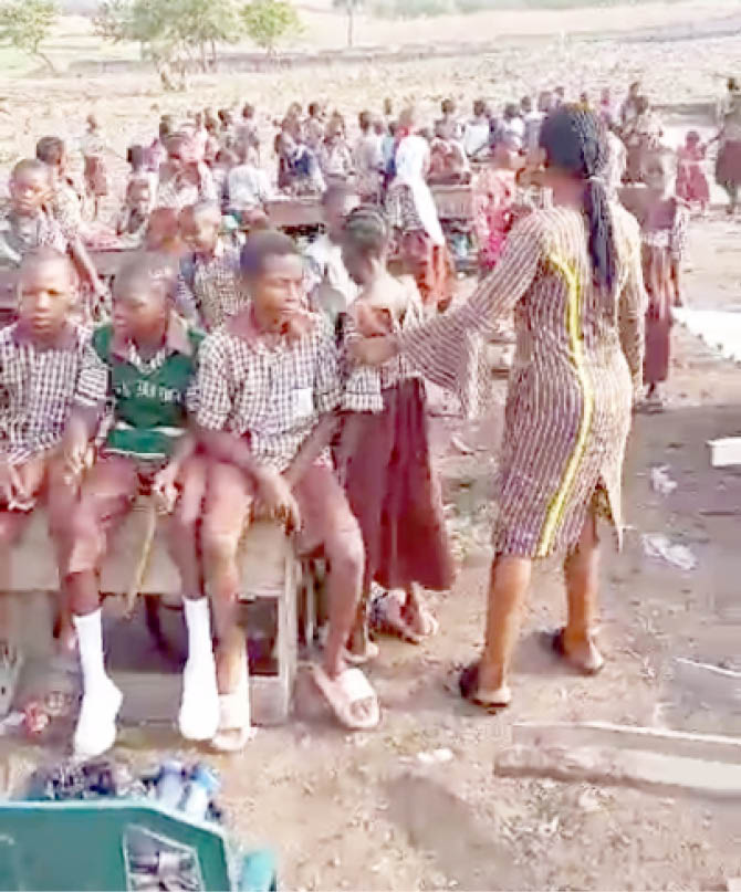 pupils of lea primary school, bagusa in a class session after windstorm blew off their makeshift wooden classroom last week