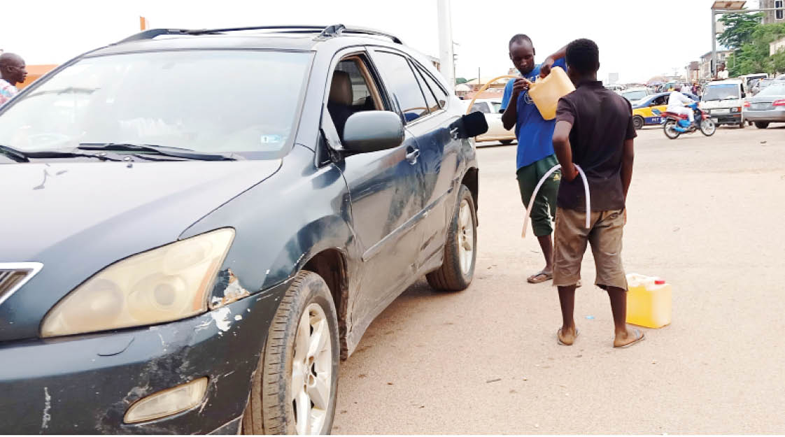 fuel hawkers attending to a customer in jabi, abuja yesterday