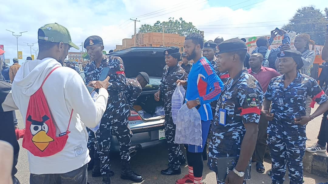 Police distribute sachet water to protesters in Plateau